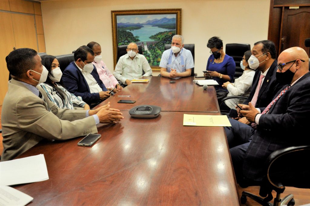 El ingeniero Salazar, junto a miembros de la administración, reunidos en la mesa revisando los documentos para firmar.