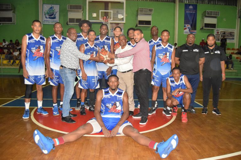 Varios miembros del equipo azul posando para fotos en la cancha de baloncesto de Haina.