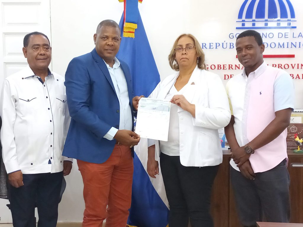 Representantes de la EGEHID entregando un cheque de RD$300 mil a dirigentes de Pony Baseball República Dominicana en un acto oficial en San Cristóbal.